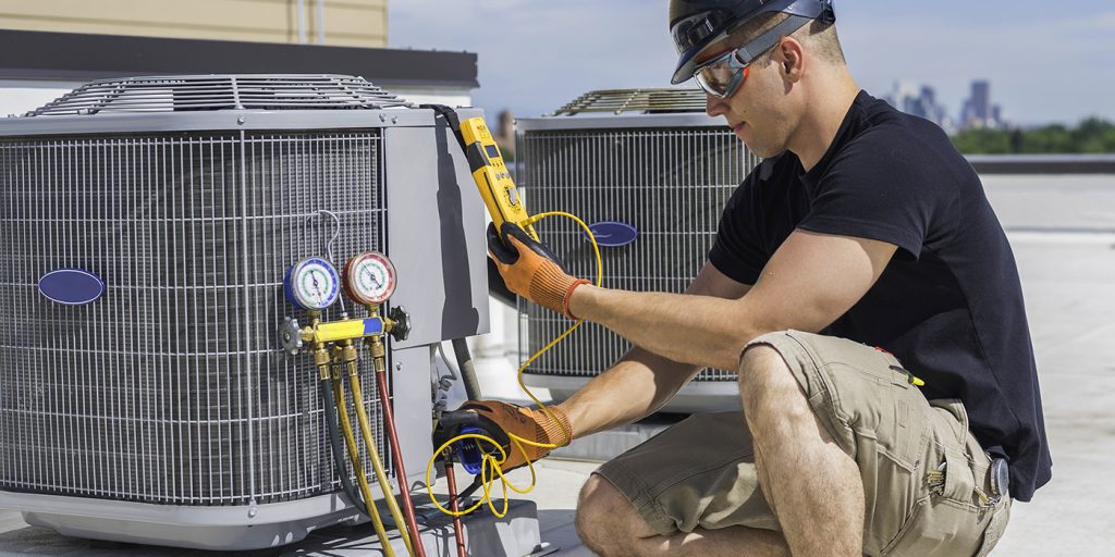 HVAC/R Technician using diagnostic equipment on outdoor unit